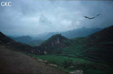 Au pied de cet épaulement dans les conglomérats éocènes se perd la rivière de Panlongdong ; à l'arrière plan le sommet de Danxiashan et son temple. (Shuitang, Liupanshui, Panxian, Guizhou)