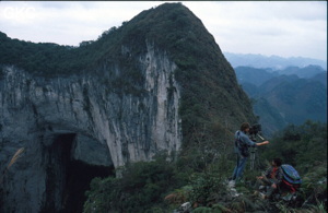 Le haut du puits de 370 m de la Gebihe, vue sur le porche fossile qui donne dans le puits. Denis Van Berleere entrain d'œuvrer à la prises de vue. Ziyun/Guizhou. Ziyun/Guizhou.