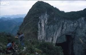 Le haut du puits de 370 m de la Gebihe, vue sur le porche fossile qui donne dans le puits. Denis Van Berleere entrain d'œuvrer à la prises de vue. Ziyun/Guizhou.