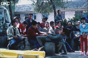 Attente des véhicules dans la cour de l'hôtel du gouvernement de Ziyun Guizhou. B. Collignon lit toujours, les enfants jouent.