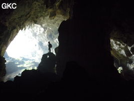 A contre-jour, un puissant pilier stalagmitique occupe la galerie de l'entrée supérieure de la grotte de Shuidong 水洞 (Qiannan 黔南, Pingtang 平塘, Guizhou 贵州省, Chine).