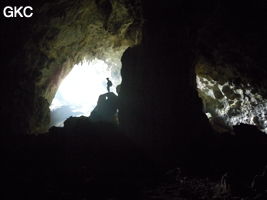 A contre-jour, un puissant pilier stalagmitique occupe la galerie de l'entrée supérieure de la grotte de Shuidong 水洞 (Qiannan 黔南, Pingtang 平塘, Guizhou 贵州省, Chine).