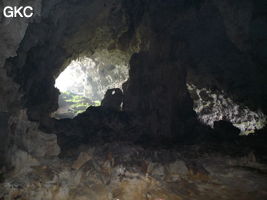 A contre-jour, un puissant pilier stalagmitique occupe la galerie de l'entrée supérieure de la grotte de Shuidong 水洞 (Qiannan 黔南, Pingtang 平塘, Guizhou 贵州省, Chine).