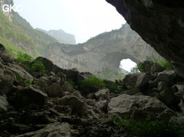 Dans la paroi est de l'énorme effondrement (un Tiankeng de pente dégénéré) de 200 m de diamètre, un gros porche perché forme un pont-naturel. Grotte de Dajing dong Qun 大井洞. (Dajing 大井, Qiannan 黔南, Luodian罗甸, Guizhou 贵州省, Chine)