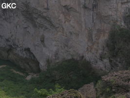 Dans l'énorme effondrement (un Tiankeng de pente dégénéré) de 200 m de diamètre. Un plan d'eau, occupe le coin est,  il correspond à un regard sur la résurgence, comme l'indique un lent mouvement tourbillonnaire. De nombreux indices sont la preuve d'importantes fluctuations de la nappe, notamment un niveau bien marqué sur la paroi, à plus de dix mètres au-dessus du plan d'eau. Grotte de Dajing dong Qun 大井洞. (Dajing 大井, Qiannan 黔南, Luodian罗甸, Guizhou 贵州省, Chine)