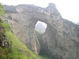 Dans la paroi est de l'énorme effondrement (un Tiankeng de pente dégénéré) de 200 m de diamètre, un gros porche perché forme un pont-naturel. Il domine plan d'eau regard sur la rivière souterraine. Grotte de Dajing dong Qun 大井洞. (Dajing 大井, Qiannan 黔南, Luodian罗甸, Guizhou 贵州省, Chine)