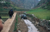 Sous la cavité de Laohuyandadong, le chenal d’écoulement canalisé sert de piste en basses eaux. A l’arrière plan, les terrasses étagées montent à l’assaut des versants, les secteurs décapés étant laissés à la broussaille. Les villages reculés bénéficient maintenant de l’électricité.