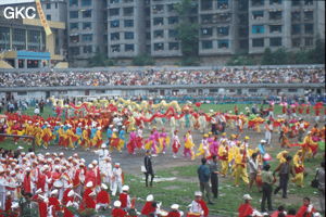 Grande fête pour célébrer le retour de Hong Kong à la Chine. Une foule à faire pâlir les commissions de sécurité les plus laxistes, les couleurs vives des costumes d'une multitude de figurants contrastent avec la grisaille des bâtiments alentours. Et le tout pour un spectacle de deux heures ou se côtoient le pire et le meilleur... Stade de Liupanshui (Suicheng, Guizhou)