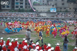 Grande fête pour célébrer le retour de Hong Kong à la Chine. Une foule à faire pâlir les commissions de sécurité les plus laxistes, les couleurs vives des costumes d'une multitude de figurants contrastent avec la grisaille des bâtiments alentours. Et le tout pour un spectacle de deux heures ou se côtoient le pire et le meilleur... Stade de Liupanshui (Suicheng, Guizhou)