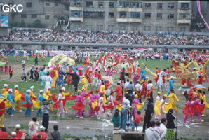 Grande fête pour célébrer le retour de Hong Kong à la Chine. Une foule à faire pâlir les commissions de sécurité les plus laxistes, les couleurs vives des costumes d'une multitude de figurants contrastent avec la grisaille des bâtiments alentours. Et le tout pour un spectacle de deux heures ou se côtoient le pire et le meilleur... Stade de Liupanshui (Suicheng, Guizhou)