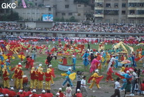 Grande fête pour célébrer le retour de Hong Kong à la Chine. Une foule à faire pâlir les commissions de sécurité les plus laxistes, les couleurs vives des costumes d'une multitude de figurants contrastent avec la grisaille des bâtiments alentours. Et le tout pour un spectacle de deux heures ou se côtoient le pire et le meilleur... Stade de Liupanshui (Suicheng, Guizhou)