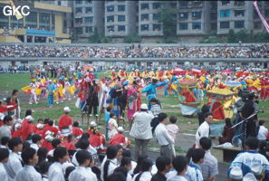 Grande fête pour célébrer le retour de Hong Kong à la Chine. Une foule à faire pâlir les commissions de sécurité les plus laxistes, les couleurs vives des costumes d'une multitude de figurants contrastent avec la grisaille des bâtiments alentours. Et le tout pour un spectacle de deux heures ou se côtoient le pire et le meilleur... Stade de Liupanshui (Suicheng, Guizhou)