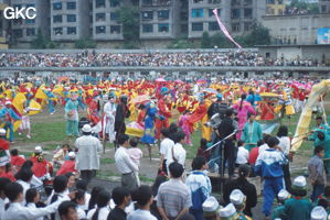 Grande fête pour célébrer le retour de Hong Kong à la Chine. Une foule à faire pâlir les commissions de sécurité les plus laxistes, les couleurs vives des costumes d'une multitude de figurants contrastent avec la grisaille des bâtiments alentours. Et le tout pour un spectacle de deux heures ou se côtoient le pire et le meilleur... Stade de Liupanshui (Suicheng, Guizhou)