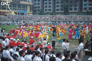 Grande fête pour célébrer le retour de Hong Kong à la Chine. Une foule à faire pâlir les commissions de sécurité les plus laxistes, les couleurs vives des costumes d'une multitude de figurants contrastent avec la grisaille des bâtiments alentours. Et le tout pour un spectacle de deux heures ou se côtoient le pire et le meilleur... Stade de Liupanshui (Suicheng, Guizhou)