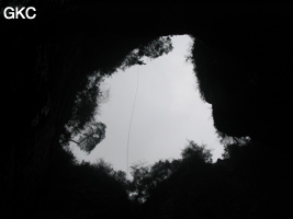 A contre jour le puits d'entrée de 155 mètres du gouffre de Xiaokengyan 消坑岩 .(Banzhu, Zheng'an 正安, Zunyi, Guizhou)