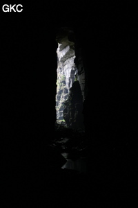 En contre-jour l'entrée de la grotte de Longqiaogedong (Grotte de la pagode de l'arche du dragon) 龙桥阁洞,  réseau de Longnudong 龙女洞. (Shipin, Zheng'an 正安, Zunyi Shi 遵义市, Guizhou 贵州省, Chine 中国)