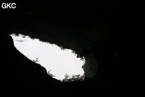 En contre-jour l'entrée de la grotte de Longqiaogedong (Grotte de la pagode de l'arche du dragon) 龙桥阁洞,  réseau de Longnudong 龙女洞. (Shipin, Zheng'an 正安, Zunyi Shi 遵义市, Guizhou 贵州省, Chine 中国)