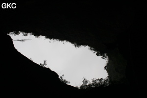 En contre-jour l'entrée de la grotte de Longqiaogedong (Grotte de la pagode de l'arche du dragon) 龙桥阁洞,  réseau de Longnudong 龙女洞. (Shipin, Zheng'an 正安, Zunyi Shi 遵义市, Guizhou 贵州省, Chine 中国)