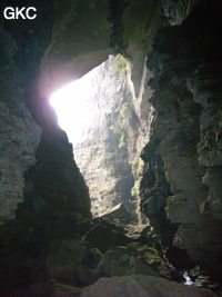 En contre-jour l'entrée de la grotte de Longqiaogedong (Grotte de la pagode de l'arche du dragon) 龙桥阁洞,  réseau de Longnudong 龙女洞. (Shipin, Zheng'an 正安, Zunyi Shi 遵义市, Guizhou 贵州省, Chine 中国)