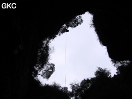 En contre jour le puits d'entrée de 155 mètres du gouffre de Xiaokengyan 消坑岩 .(Banzhu, Zheng'an 正安, Zunyi, Guizhou)