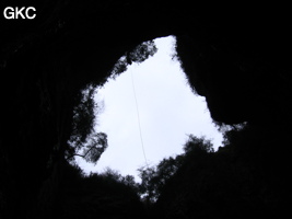 En contre jour le puits d'entrée de 155 mètres du gouffre de Xiaokengyan 消坑岩 .(Banzhu, Zheng'an 正安, Zunyi, Guizhou)