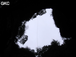 En contre jour le puits d'entrée de 155 mètres du gouffre de Xiaokengyan 消坑岩 .(Banzhu, Zheng'an 正安, Zunyi, Guizhou)