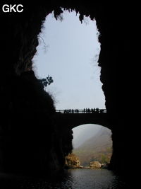 A contre-jour le porche d'entrée et le pont qui enjambe la puissante résurgence de la rivière Gesohe 革索出口. (Panxian, Liupanshui, Guizhou)