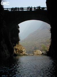 A contre-jour le porche d'entrée et le pont qui enjambe la puissante résurgence de la rivière Gesohe 革索出口. (Panxian, Liupanshui, Guizhou)