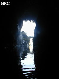 A contre-jour le porche d'entrée et le pont qui enjambe la puissante résurgence de la rivière Gesohe 革索出口. (Panxian, Liupanshui, Guizhou)