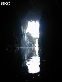 A contre-jour le porche d'entrée et le pont qui enjambe la puissante résurgence de la rivière Gesohe 革索出口. (Panxian, Liupanshui, Guizhou)